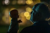 A man looks at a baby doll under the cover of darkness in THE RULE OF JENNY PEN