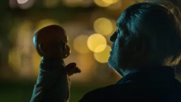 A man looks at a baby doll under the cover of darkness in THE RULE OF JENNY PEN