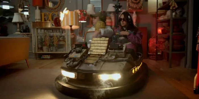A woman sits in a tricked out bumper car inside of a thrist shop in TIME TRAVEL IS DANGEROUS