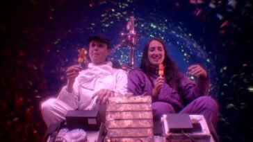 Two women enjoy ice cream in a colorful wormhole while eating ice cream in TIME TRAVEL IS DANGEROUS