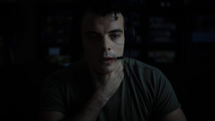 A sweaty, out of breath man wearing a gaming headset is seen holding his throat in FOREVER WAR (PLAYING AS PART OF THE DUNWICH HORRORS BLOCK AT BUFF 25).