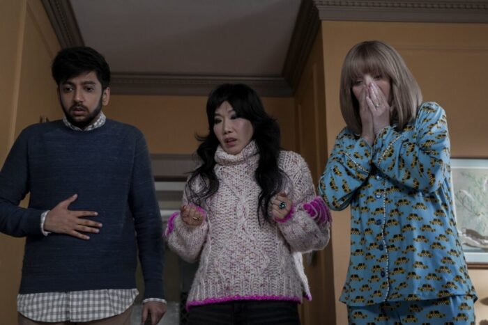 A man and two women look very concerned while looking toward the camera.