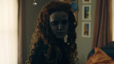 A woman with long hair wearing a porcelain mask