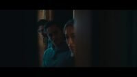 three faces emerge from an open room, peaking around a corner