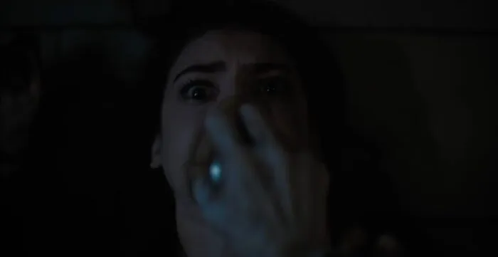 A woman with a breathing apparatus being held against her mouth