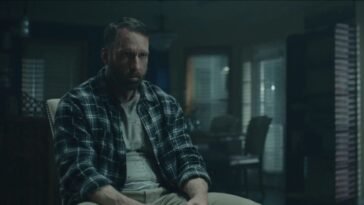 A man sits in a chair.