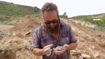 Chad looks at the blue dirt and the black rocks