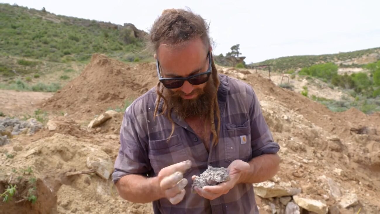 Chad looks at the blue dirt and the black rocks