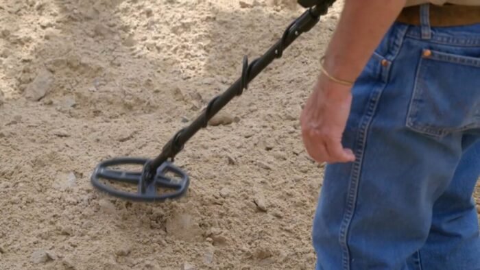 Charlie Boy runs his metal detector over the dirt