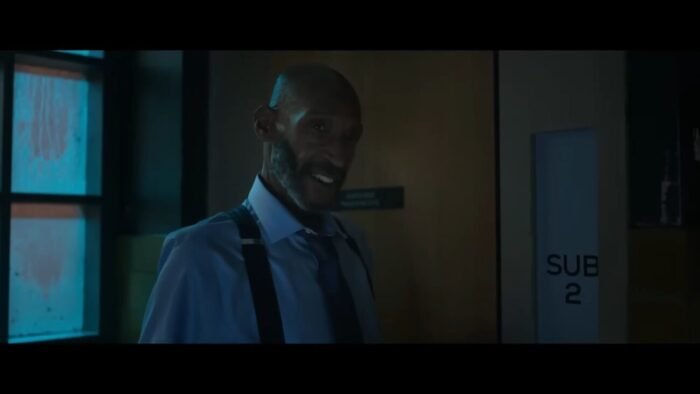 Bloodworth (Tony Todd) standing by a door