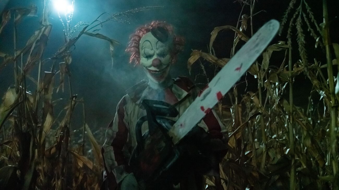 A clown carries a large chainsaw through a cornfield in CLOWN IN A CORNFIELD