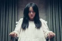 A woman in a white dress is tied to a chair in HOLY NIGHT: DEMON HUNTERS