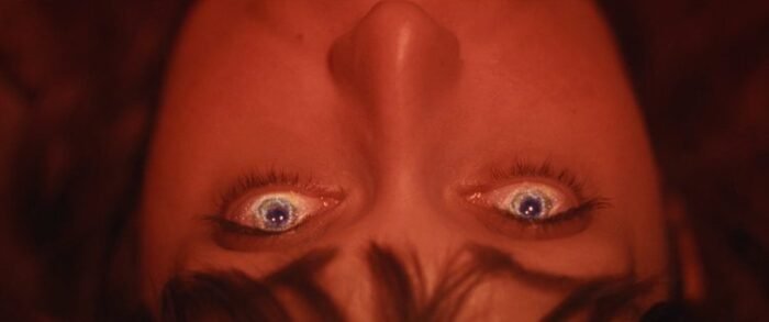 the upside-down face of a woman with cloudy eyes.