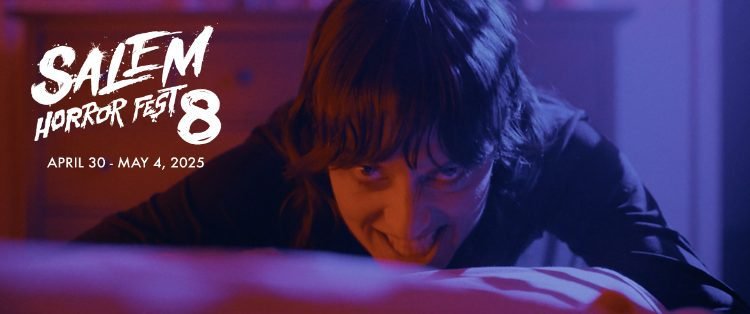 A woman is seen at the foot of a bed bowing her head while looking toward the camera with an evil smile in HOUSE OF ASHES