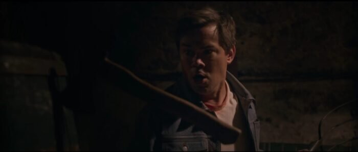 A man looks at the axe that narrowly missed him, lodged in the wall beside him. (I DON'T UNDERSTAND YOU)