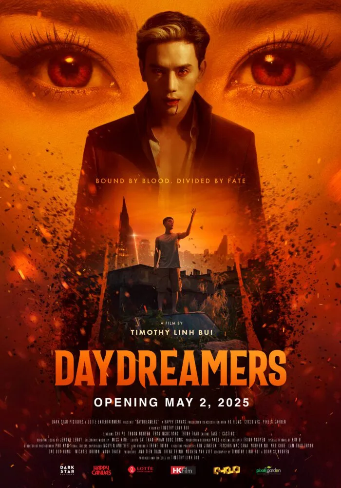 The poster for Daydreamers shows an orange sky with a pair of eyes peering over the shoulders of a man surrounded by fiery embers, and the opaque display of another man lifting his arm into the sky. 