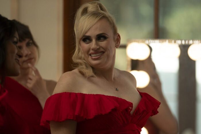 A woman in a red dress smiles