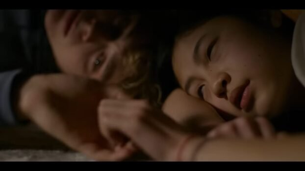 Piper and Andy are laying down holding hands
