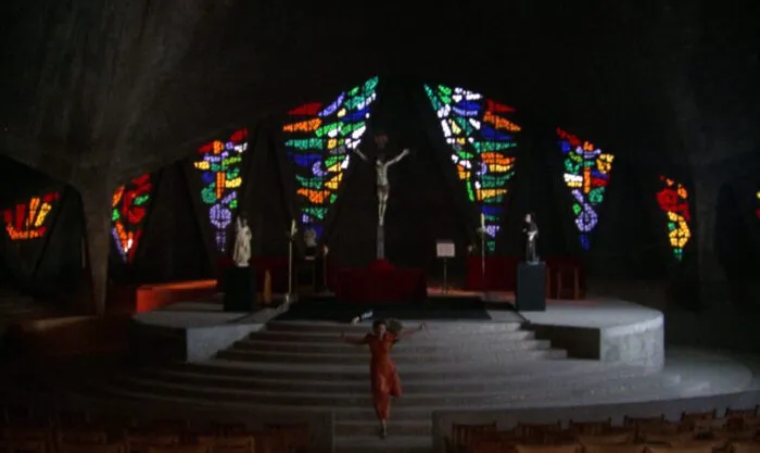 A woman is seen running down the stairs of a church altar