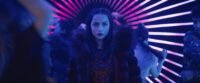 Eve is standing in a neon hallway surrounded by people