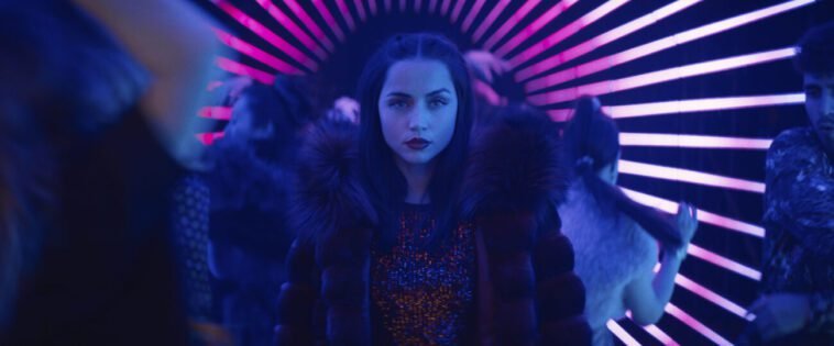Eve is standing in a neon hallway surrounded by people