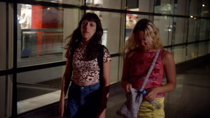Two women are walking through an airport