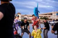 A group of rowdy people drop an over-sized battle axe on a man tied up on a pier in Hacked: A Double Entendre of Rage Fueled Karma