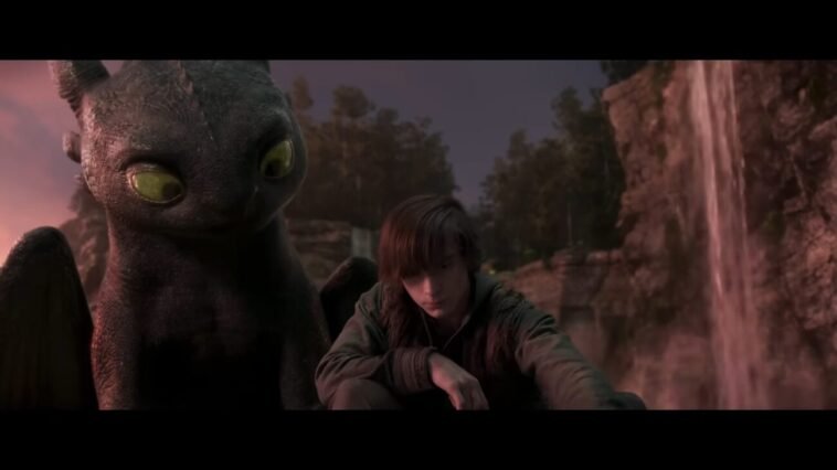 Toothless watches Hiccup draw in the sand