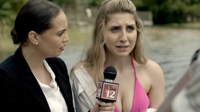 A nervous looking woman in a bikini speaks with the reporter beside her (GATOR LAKE)