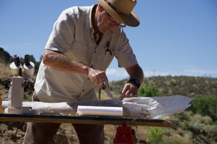 Geologist Eric Drummond uses a knife to open up a core sample and begin analyzing it. (Mystery at Blind Frog Ranch)