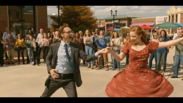 Chuck dances with a woman wearing a red dress, spinning her around.