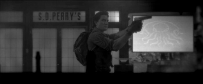 A man raises a gun in front of an S.D. Perry's
