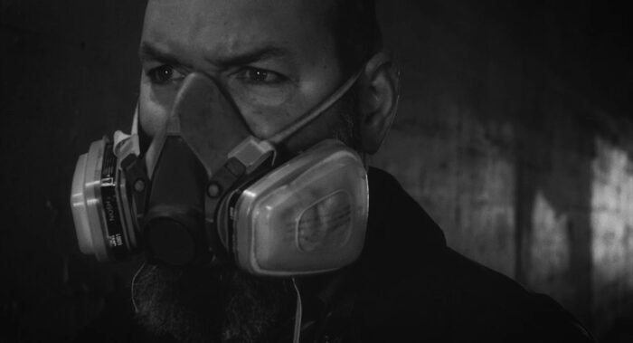 a black and white image of a man in an N95 mask.