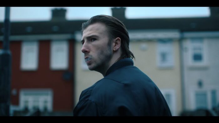 A man approaching a townhouse looks over his shoulder