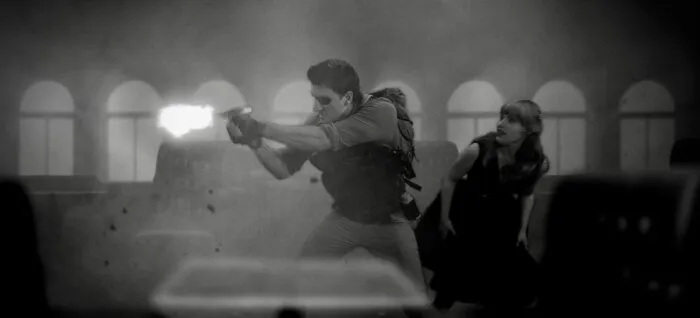 A woman ducks behind a man firing his gun on a foggy ship.