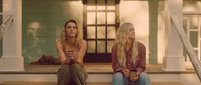 Two women sitting on a house's front steps.