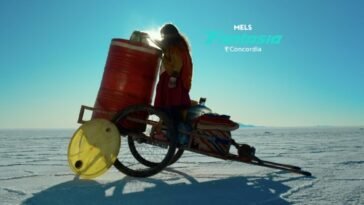 A young girl stands on a rickshaw next to a bright red barrel in the Bolivian desert (Cielo)