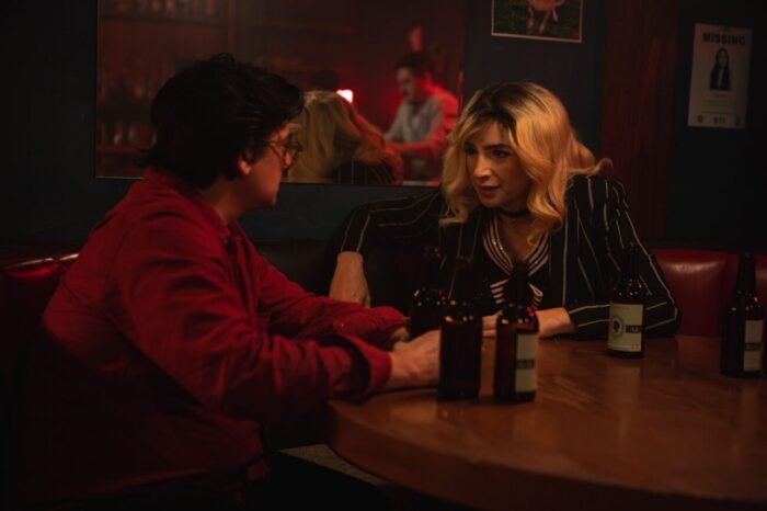 A man and a woman talk while having beers at a table in a bar (Every Heavy Thing)