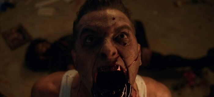 A man screaming toward the ceiling with blood pouring out of his mouth (Hold the Fort)