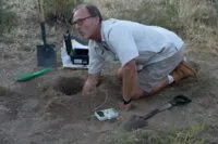 Eric tests the soil with the Geiger counter.