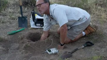 Eric tests the soil with the Geiger counter.