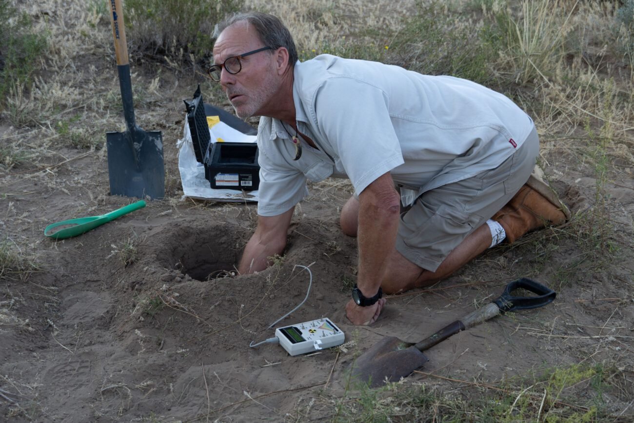 Eric tests the soil with the Geiger counter.