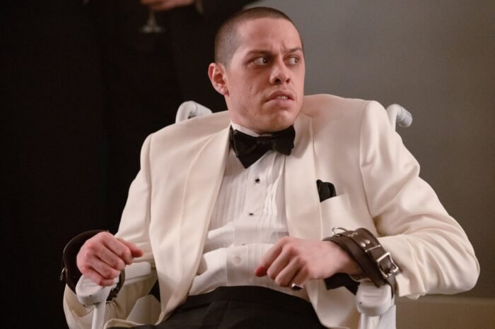 A man in a white tuxedo looks worried after discovering his hands are restrained to the chair he's sitting in (The Home / FrightFest)