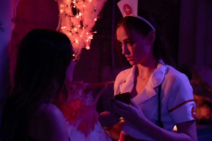a young woman in a nurse's outfit is seen talking to someone.