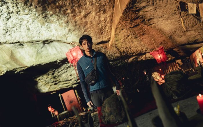 A man standing in a cave where a ritual of some sort is taking place (Haunted Mountains: The Yellow Taboo)