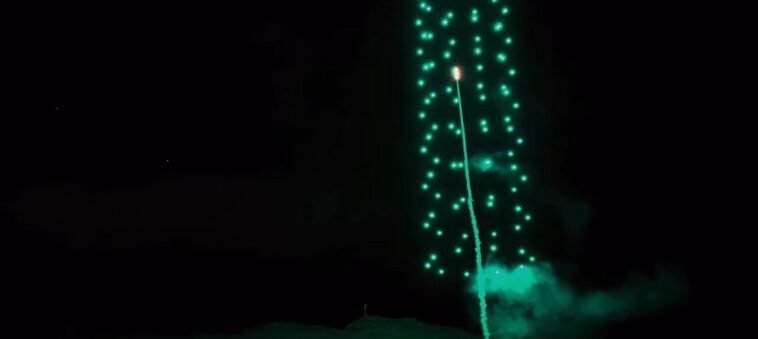 A rocket flies through the center of the drone swarm