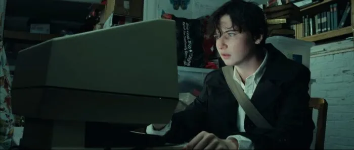 Tessa consults the microfiche machine in the library basement