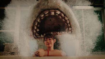 A woman texting on the phone in a bathtub has no idea a shark has emerged behind her (Hot Spring Shark Attack)