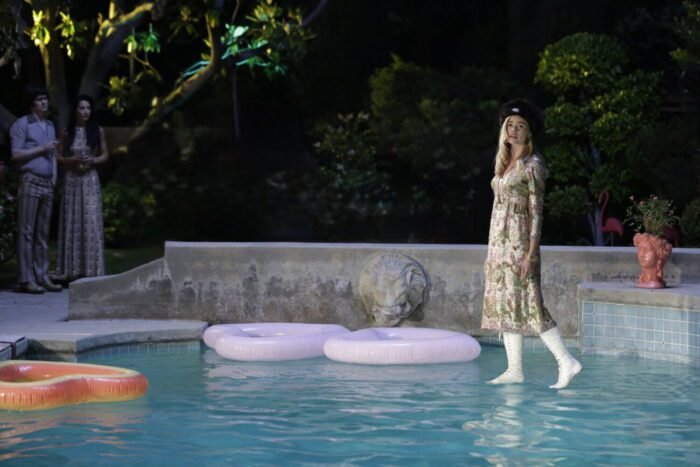 A woman walking on water in a pool next to floaties. (A Blind Bargain)