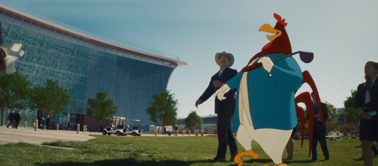 Buddy Crane (John Cena) and Foghorn Leghorn laugh together while walking on a golf course in the film, “Coyote vs. Acme” (2026).